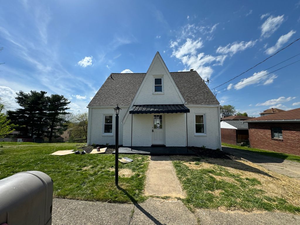 White-painted home exterior with black metal awning